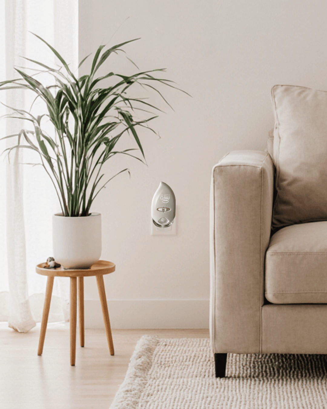 Nesmah diffuser beside a beige couch and indoor plant in guest room.